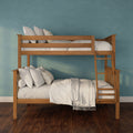 Solid wooden bunk bed with white bedding and ladder against a teal textured wall on dark hardwood floor