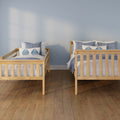 Two twin wooden bed frames with blue-and-white bedding and leaf-pattern pillows against a light blue wall on hardwood floor