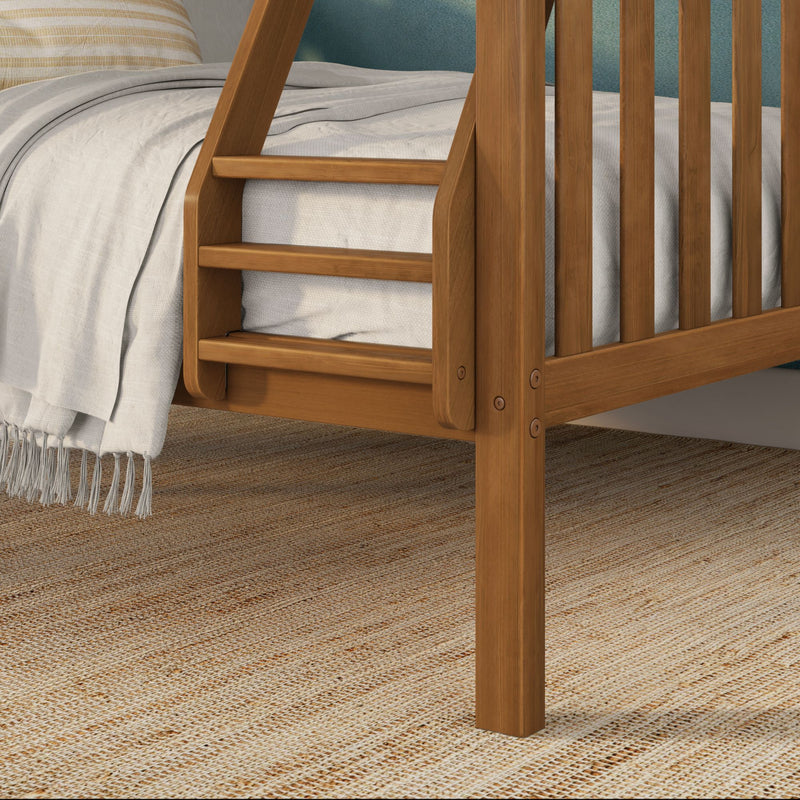 Close-up of solid oak bunk bed ladder and slatted wood rail with neutral linen bedding and woven jute rug in a modern rustic bedroom