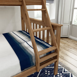 Wooden bunk bed with blue and white striped blanket on hardwood floor in a bright bedroom.