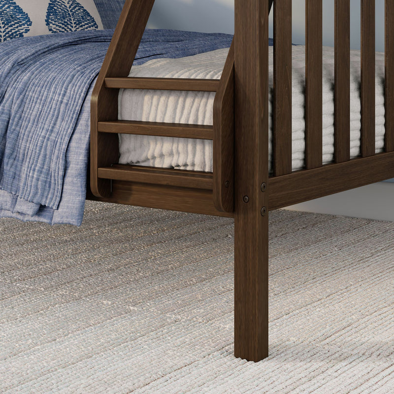 Close-up of a solid wood bed frame ladder and slats with a blue quilted blanket, white textured mattress cover and neutral woven area rug