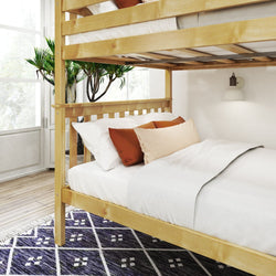 Wooden bunk bed with white bedding and rust-colored pillows in a modern bedroom with natural light and decorative plant.