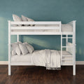 White wooden bunk bed with ladder and neutral beige bedding against a teal textured accent wall on dark hardwood floor