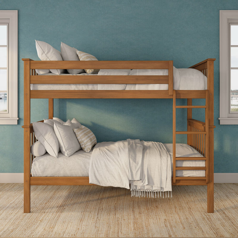 Wooden twin bunk bed with ladder, neutral linens and striped pillows against a teal textured accent wall and windows in a bright kids' bedroom