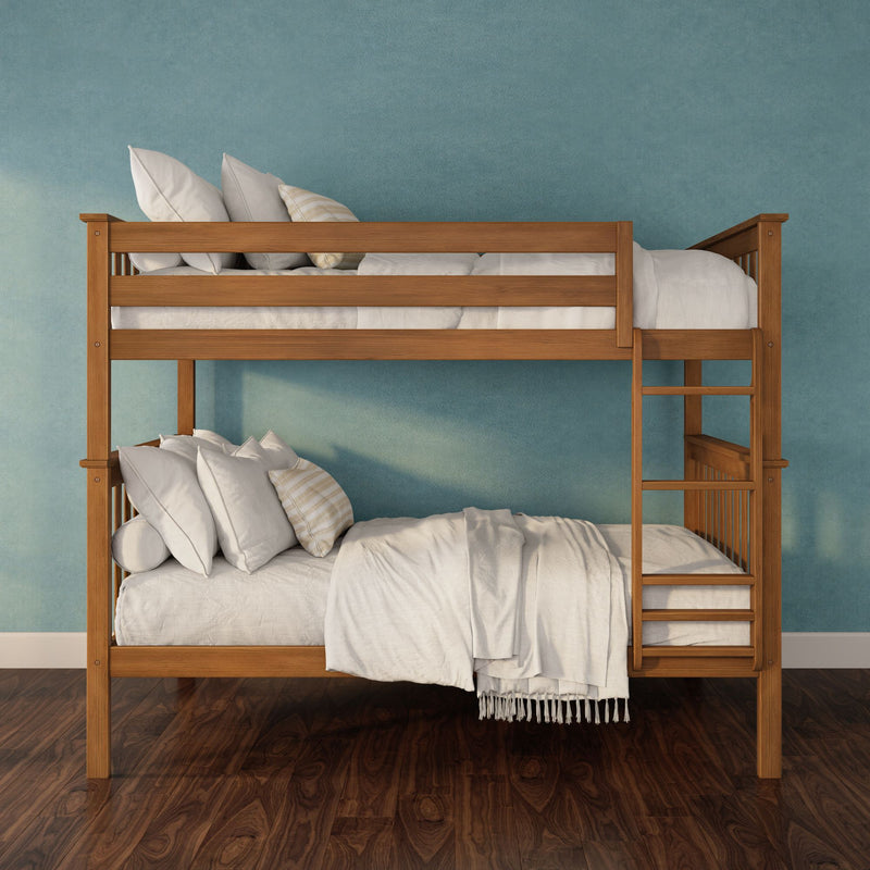 Twin-over-twin wooden bunk bed with natural wood finish, white linens and pillows against a teal textured wall on dark hardwood floor — space-saving kids’ bedroom décor