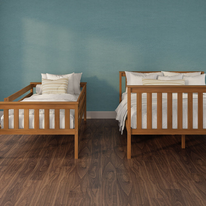 Minimalist bedroom interior with two wooden twin beds, white bedding and striped pillows against a teal accent wall on dark hardwood floor