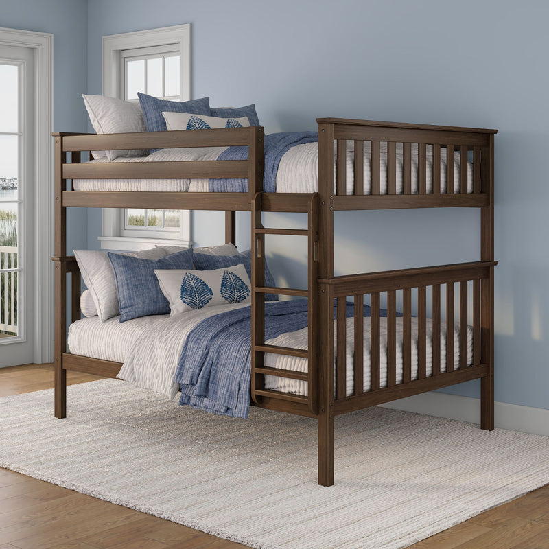 Dark walnut wooden bunk bed with ladder and slatted guardrails styled with blue-and-white coastal bedding in a bright bedroom