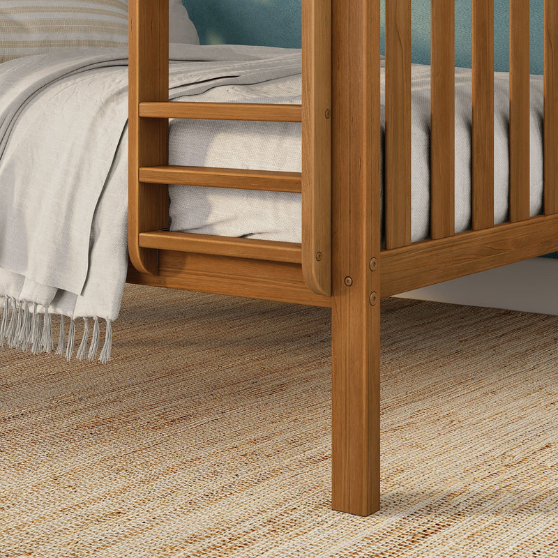 Close-up of solid oak slatted bed frame and wooden platform bed detail with beige linen bedding, fringed throw blanket and woven jute rug underneath
