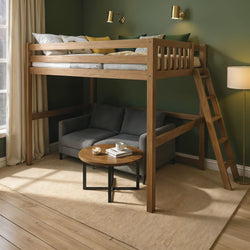 Wooden loft bed with ladder over gray sofa, round wooden coffee table and floor lamp in a cozy modern studio with green walls and natural light