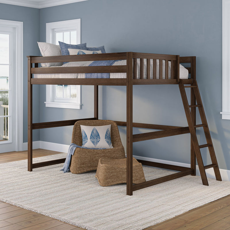 Solid dark wood loft bed with ladder, blue coastal bedding and pillows in a light blue bedroom with wicker chair and rattan ottoman