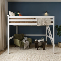 Modern white loft bed with ladder in a small bedroom, cozy reading nook with green armchair, round table, books, knit throw and navy blue accent wall