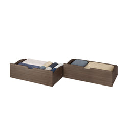 Walnut wood under-bed storage drawers filled with folded blankets, sheets and pillows for space-saving bedroom organization