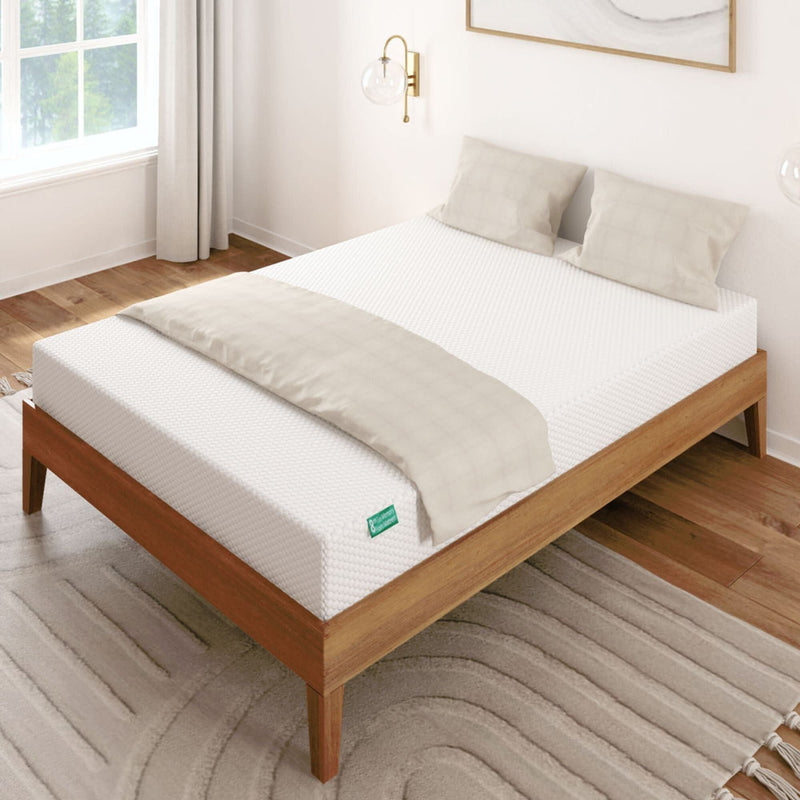 Wooden bed with white mattress and beige pillows in a modern bedroom setting.