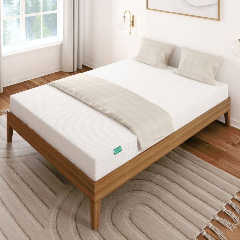 Modern minimalist bedroom with a comfortable queen-size mattress on a wooden bed frame, featuring white bedding and decor.