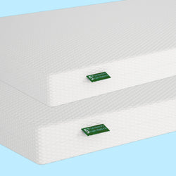 Stack of two gel mattresses with textured white covers on a blue background.