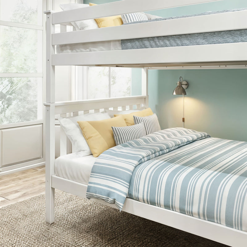 White wooden bunk bed with blue-and-white striped bedding, yellow accent pillows, wall sconce and large window in a bright coastal-style bedroom