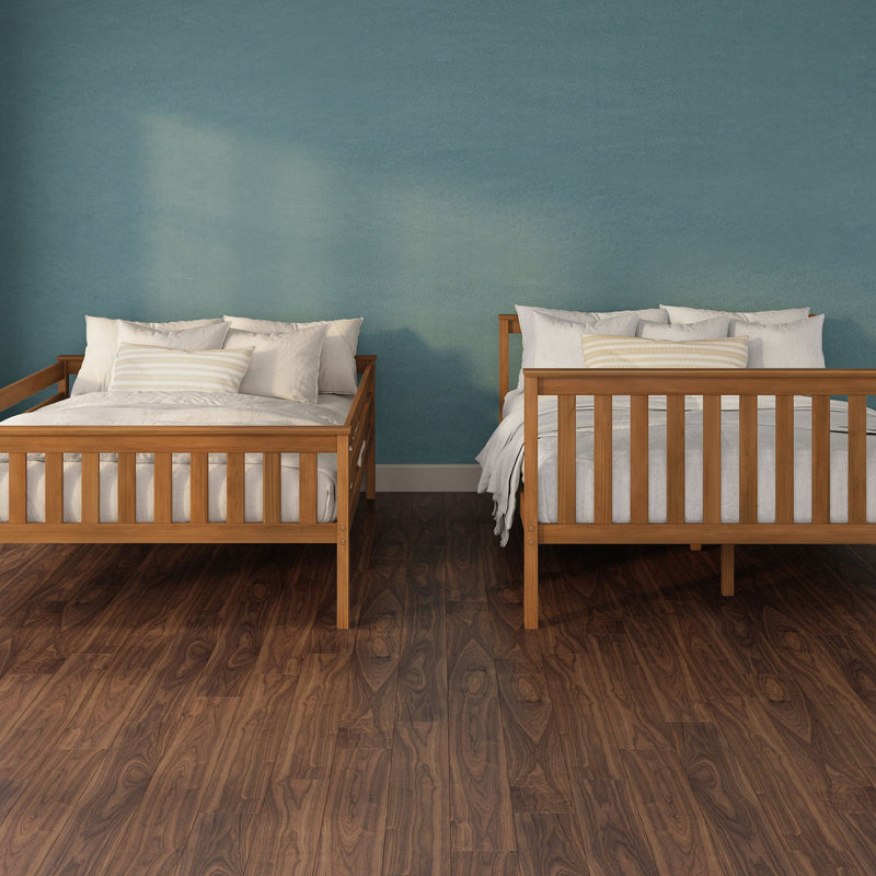 Two wooden twin beds with white bedding and striped pillows against a teal textured wall on dark hardwood floor, cozy modern bedroom