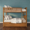 Solid wood bunk bed with ladder and under-bed storage drawers, styled with white bedding and decorative pillows against a teal textured wall in a modern kids' bedroom