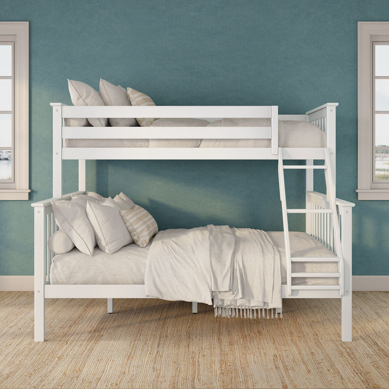 White wooden bunk bed with ladder, beige bedding and pillows against a teal accent wall in a coastal-style bedroom with windows and woven rug