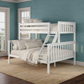 White wooden twin-over-full bunk bed with ladder and beige bedding in a coastal teal kids' bedroom with large windows and jute rug