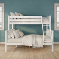 White wooden bunk bed with ladder and beige bedding against a teal textured wall between two windows in a bright kids' bedroom