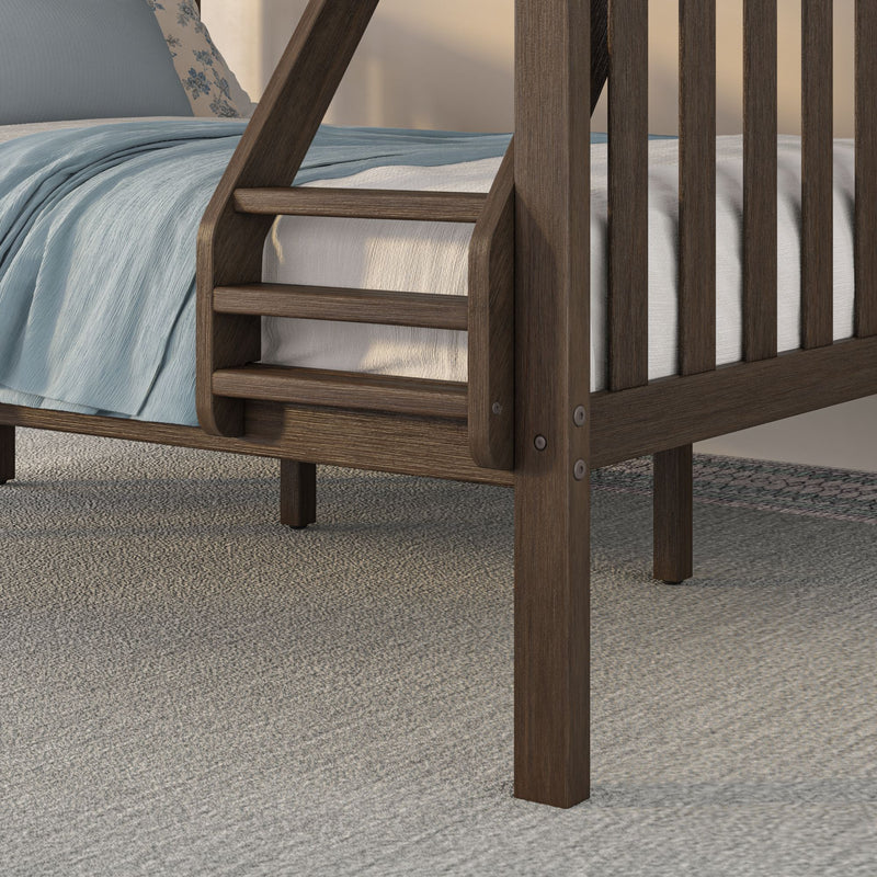 Close-up of a dark walnut wooden bunk bed ladder and slatted bed frame with light blue linen bedding and textured beige carpet