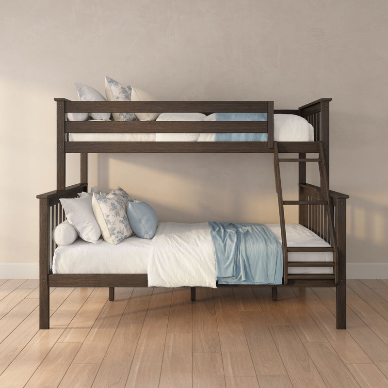 Dark wooden twin-over-full bunk bed with ladder, white bedding, blue throw and floral pillows on hardwood floor against a neutral wall