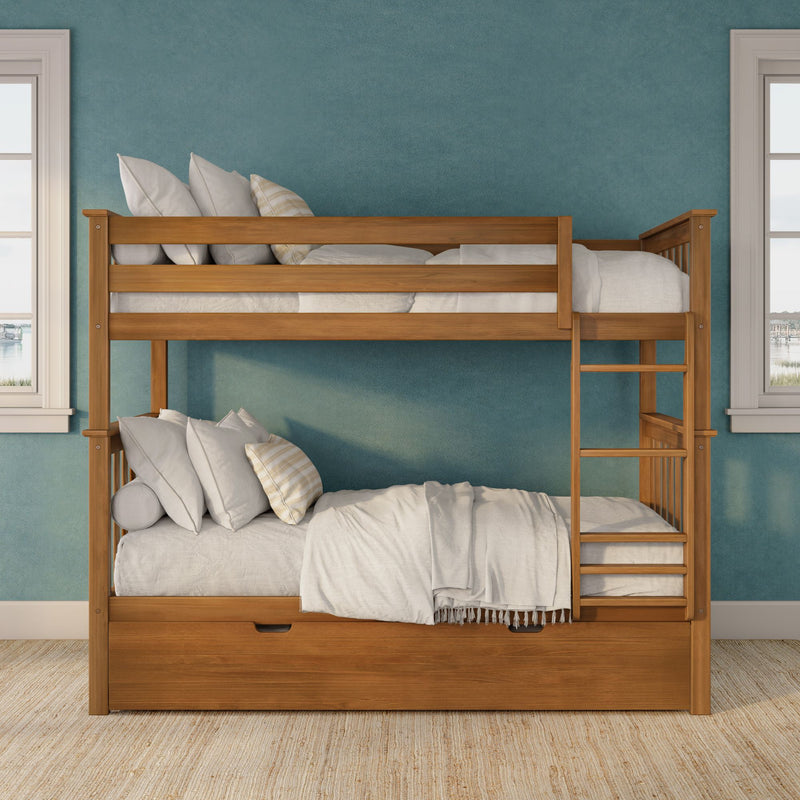 Solid wood bunk bed with ladder and pull-out storage drawers, white linens and decorative pillows against a teal textured accent wall flanked by windows