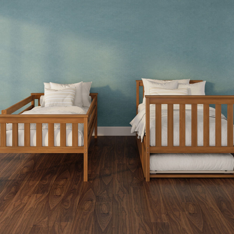 Two wooden twin beds with white linens and striped pillows against a teal textured wall on dark hardwood flooring, minimalist bedroom interior design