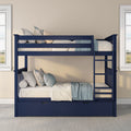 Navy blue wooden bunk bed with ladder and under-bed storage drawer, styled with cream bedding, blue throw and decorative pillows in a bright bedroom