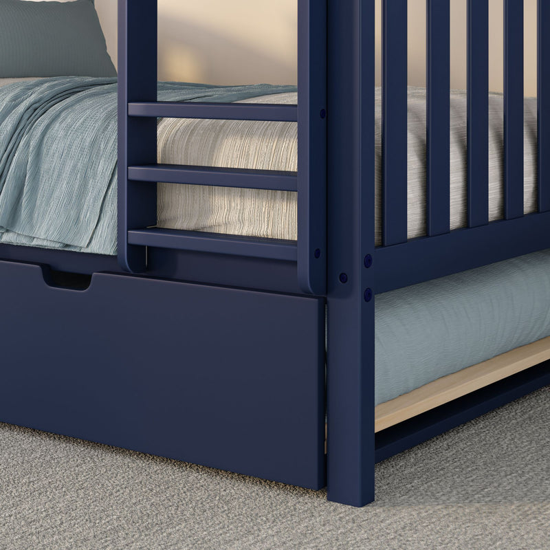 Close-up of navy blue wooden bunk bed with ladder and safety rails, light blue textured bedding and built-in under-bed storage drawer on gray carpet