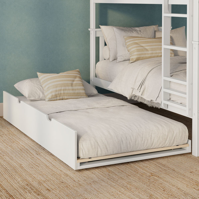 White wooden bunk bed with pull-out trundle, neutral linen bedding and beige striped pillows against teal accent wall on woven jute rug