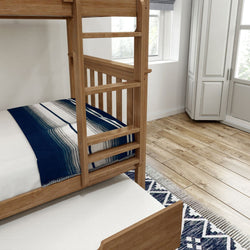 Wooden bunk bed with blue and white striped blanket in cozy bedroom, featuring hardwood floors and a patterned rug.