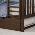 Close-up of dark wood bunk bed ladder and under-bed storage drawer with blue quilt and white textured bedding