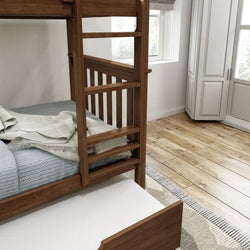 Wooden bunk bed with storage drawer in a bright, modern bedroom featuring hardwood floors and white cabinetry.