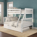 White wooden bunk bed with ladder and pull-out trundle, beige bedding and striped pillows against a teal textured wall