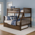 Wooden twin-over-full bunk bed with ladder and trundle in modern kids’ bedroom, blue-and-white quilted bedding, light-blue walls and windowed natural light