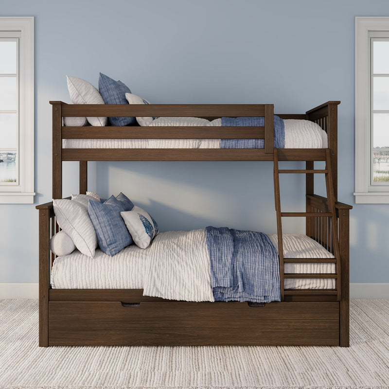 Dark wood bunk bed with ladder and under-bed storage drawer, styled with blue-and-white quilted bedding and pillows in a light-blue coastal kids' bedroom with windows
