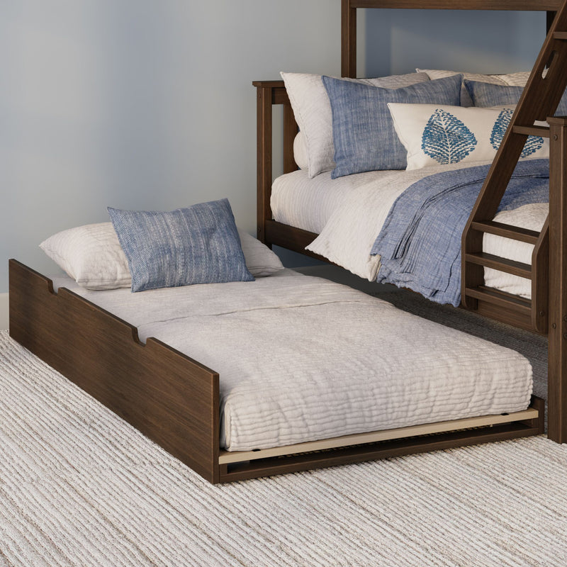 Wooden bunk bed with pull-out trundle, white quilted bedding and blue decorative pillows on a textured beige rug