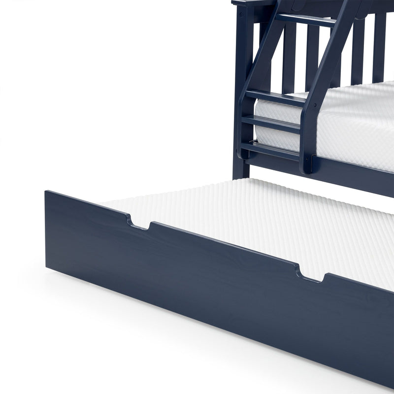 Navy blue wooden bunk bed with built-in ladder, slatted guardrail and pull-out trundle mattress on white textured mattresses, modern kids bedroom furniture