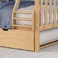 Light natural wood bunk bed ladder and slatted rails with blue quilted bedding, gray mattress and built-in underbed storage drawer
