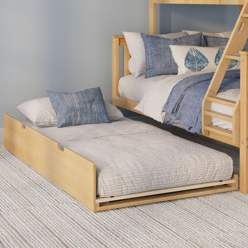 Light wood bunk bed with pull-out trundle, neutral quilted bedding and blue decorative pillows in a coastal-style kids' bedroom