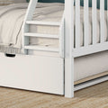 Close-up of white wooden bunk bed ladder and slats with beige linen bedding and under-bed storage drawer on woven jute rug