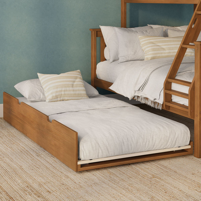Wooden bunk bed with pull-out trundle, neutral linen bedding and striped pillows against a teal textured wall in a space-saving kids or guest room