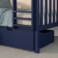 Close-up of navy blue wooden bunk bed with ladder and pull-out storage drawer, teal textured bedding and neutral mattress