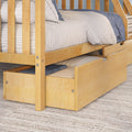 Maple wooden bunk bed with under-trundle storage drawer, white quilted bedding and blue throw on textured rug, modern kids bedroom furniture