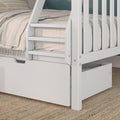 Close-up of white wooden bunk bed ladder and safety rails with under-bed pull-out storage drawer, beige linen bedding and woven jute rug, modern kids' bunk bed design