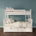White wooden bunk bed with ladder and under-bed storage drawers, beige linens and pillows against a teal wall on hardwood floor
