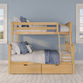 Wooden bunk bed with ladder, blue quilted bedding and pillows, and under-bed storage drawers in a coastal-inspired kids' bedroom with light blue walls and twin windows