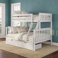 White wooden bunk bed with ladder and pull-out storage drawers, neutral linens and pillows against teal textured walls in a cozy coastal bedroom